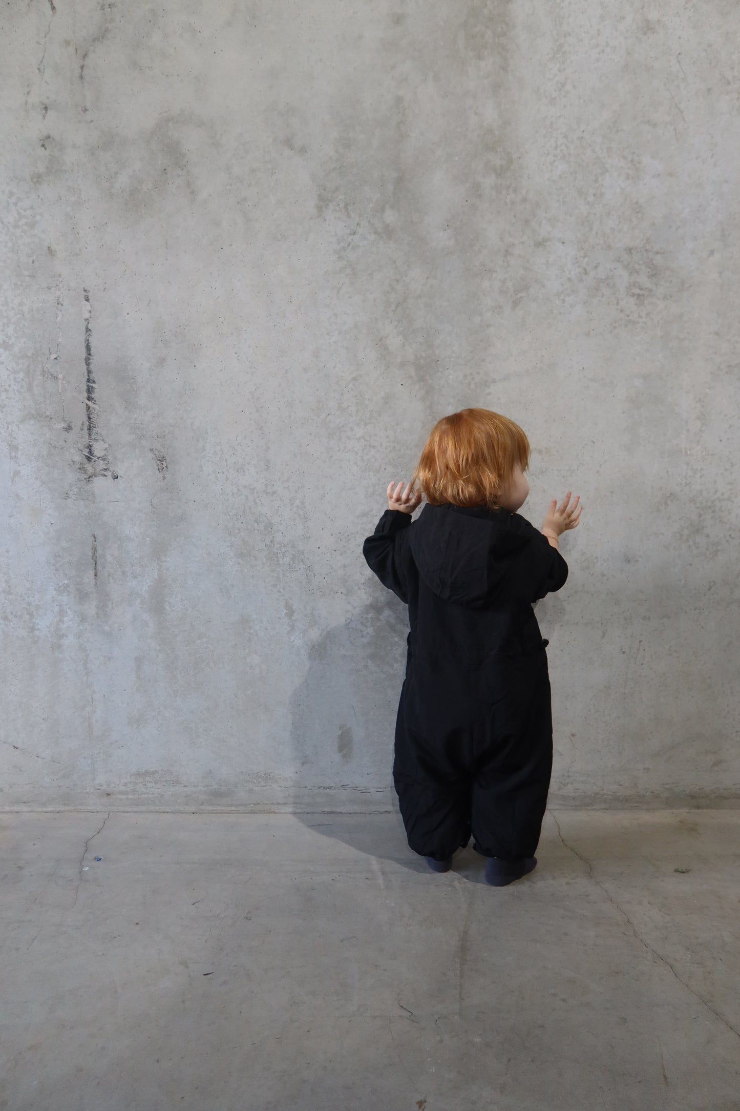 Back view of the Windbreaker Boiler Suit with child facing away, displaying full coverage and elastic ankle cuffs.
