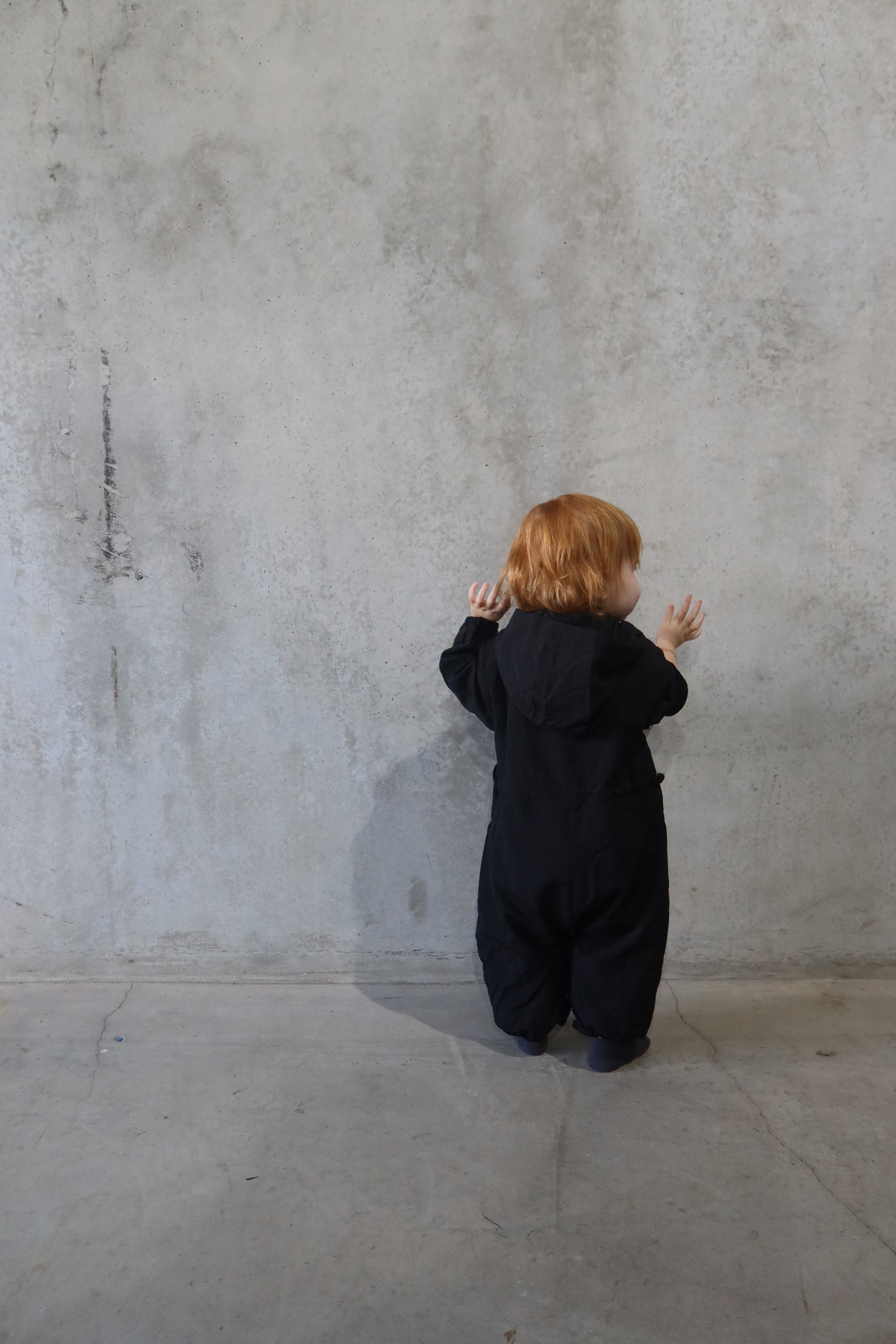 Back view of the Windbreaker Boiler Suit with child facing away, displaying full coverage and elastic ankle cuffs.